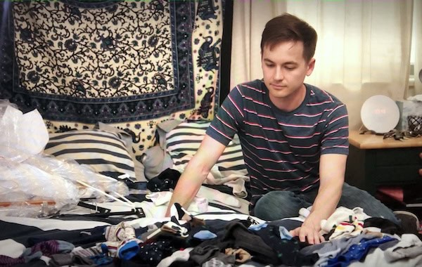 Man organizing his bedroom from clutter