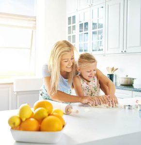 Woman and daughter baking in clean, decluttered, organized kitchen