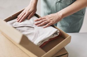 Professional organizer folding clothes in a box
