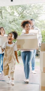 Girls walking into a new home and carrying boxes into an organized home